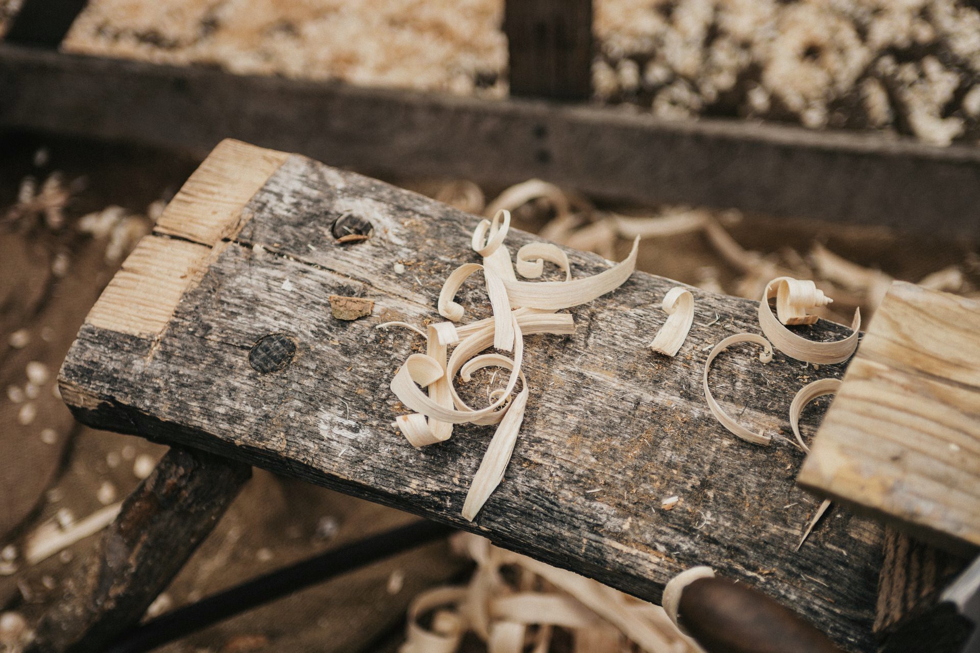 Rough cedar beam with fresh shavings on a workbench