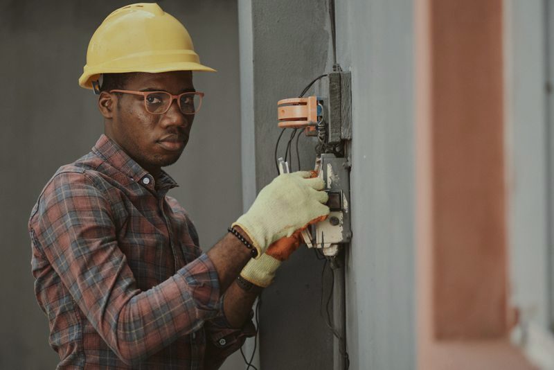 Electrician working at an open electrical panel
