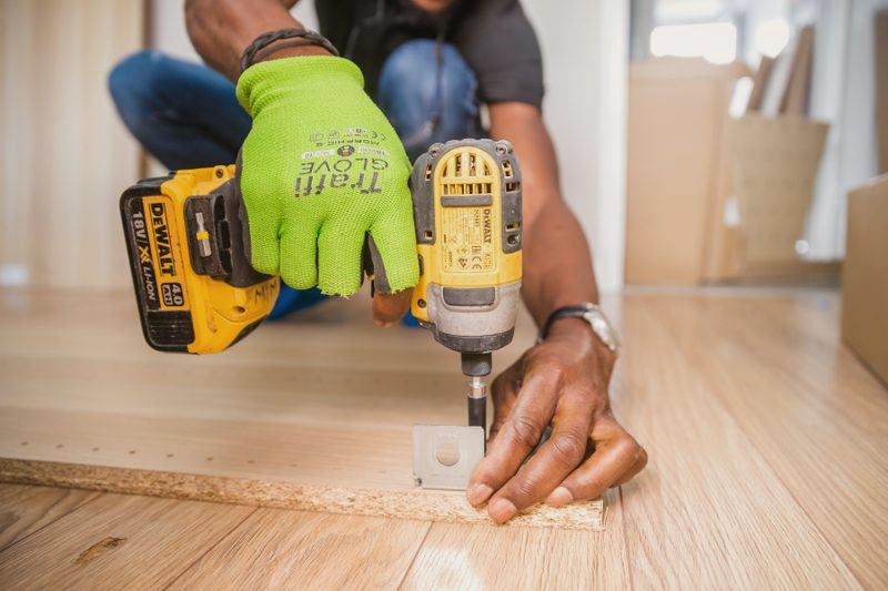 Drill driving a fastener into wood flooring on a job site